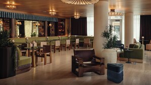 A spacious lobby with a high ceiling, wooden flooring, and a variety of seating options including sofas, chairs, and a bar area. - Experience Zilker + South Lamer | Private Balcony | Pool, Dining, Bar | The Code (Austin)