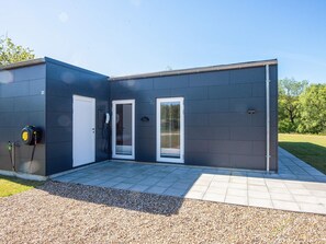 A modern building with a flat roof, a gravel driveway, and a paved walkway.