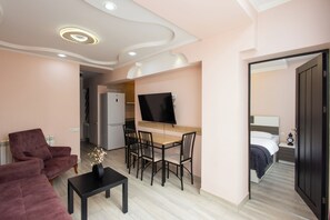 Appartement Standard, balcon | Coin séjour | Télévision à écran plat de 50 pouces avec chaînes par câble