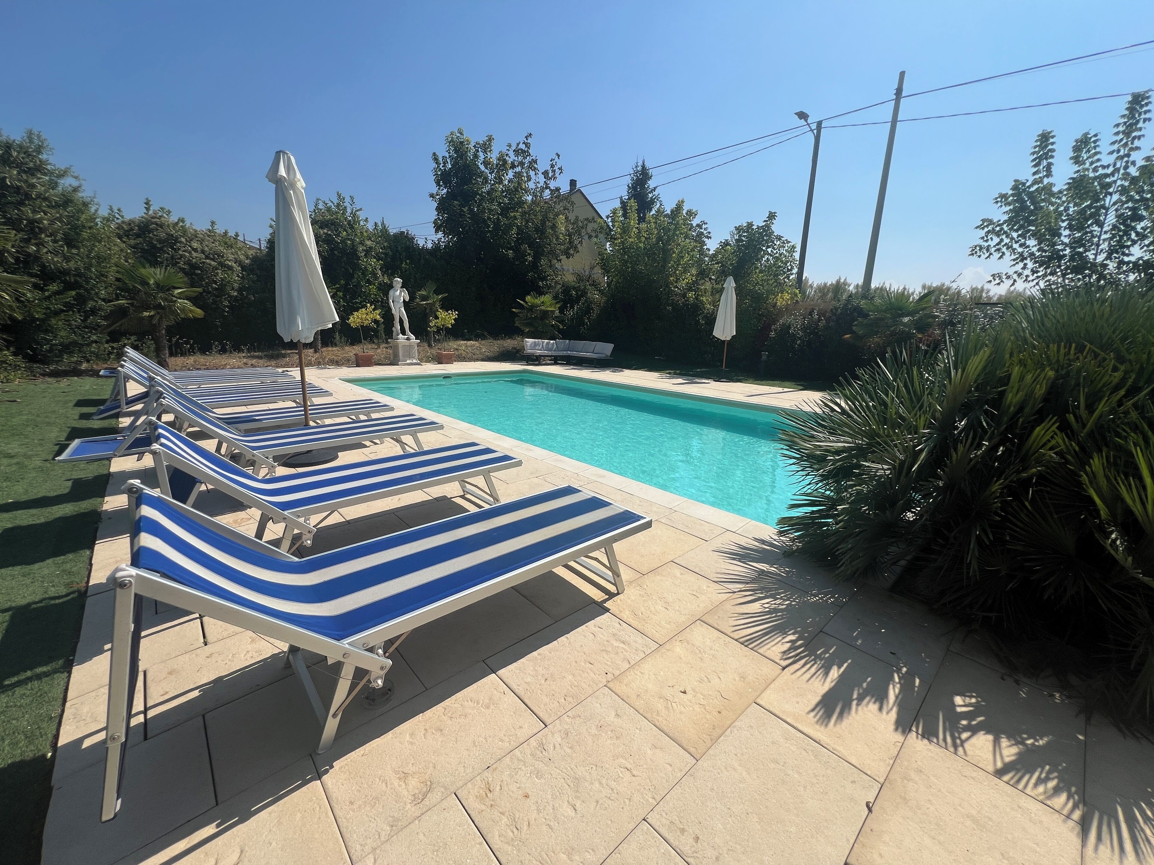A swimming pool with lounge chairs and umbrellas.