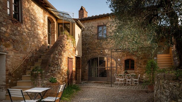 A stone building with a patio, outdoor seating, and a staircase. - Apartment 'La Banditina' with Private Terrace, Wi-Fi and Air Conditioning (Vico dʼArbia)
