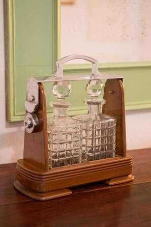 A wooden radio with two crystal decanters on a table.