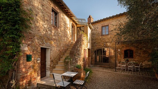 A stone building with a staircase, outdoor seating, and a gravel courtyard. - Apartment 'Tiziana' with Shared Garden and Wi-Fi (Vico dʼArbia)
