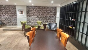 Un salón de conferencias con una gran mesa y seis sillas, rodeado de estanterías.