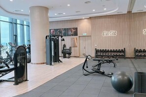 A gym with cardio machines, weight benches, and a large exercise ball. - Alacarte Halong Bay (Ha Long)