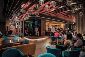 Un área de estar moderna con asientos, un bar y un escenario para espectáculos.