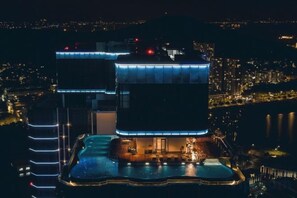 Ein mehrstöckiges Hotel mit Poolbereich, das einen markanten Dachterrasse mit Blick auf die Stadtlandschaft bietet.