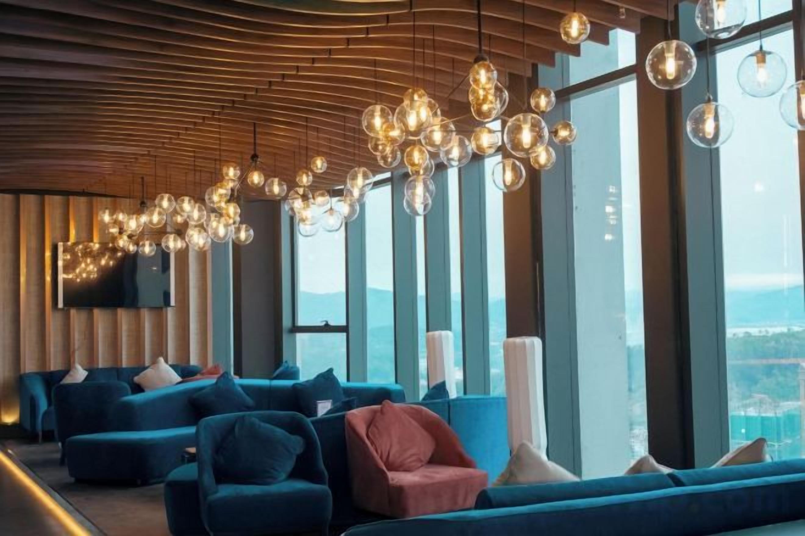 A modern lounge area with sofas and a large window offering a view.