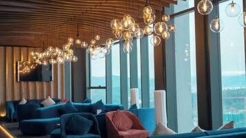 A modern lounge area with sofas and a large window offering a view.