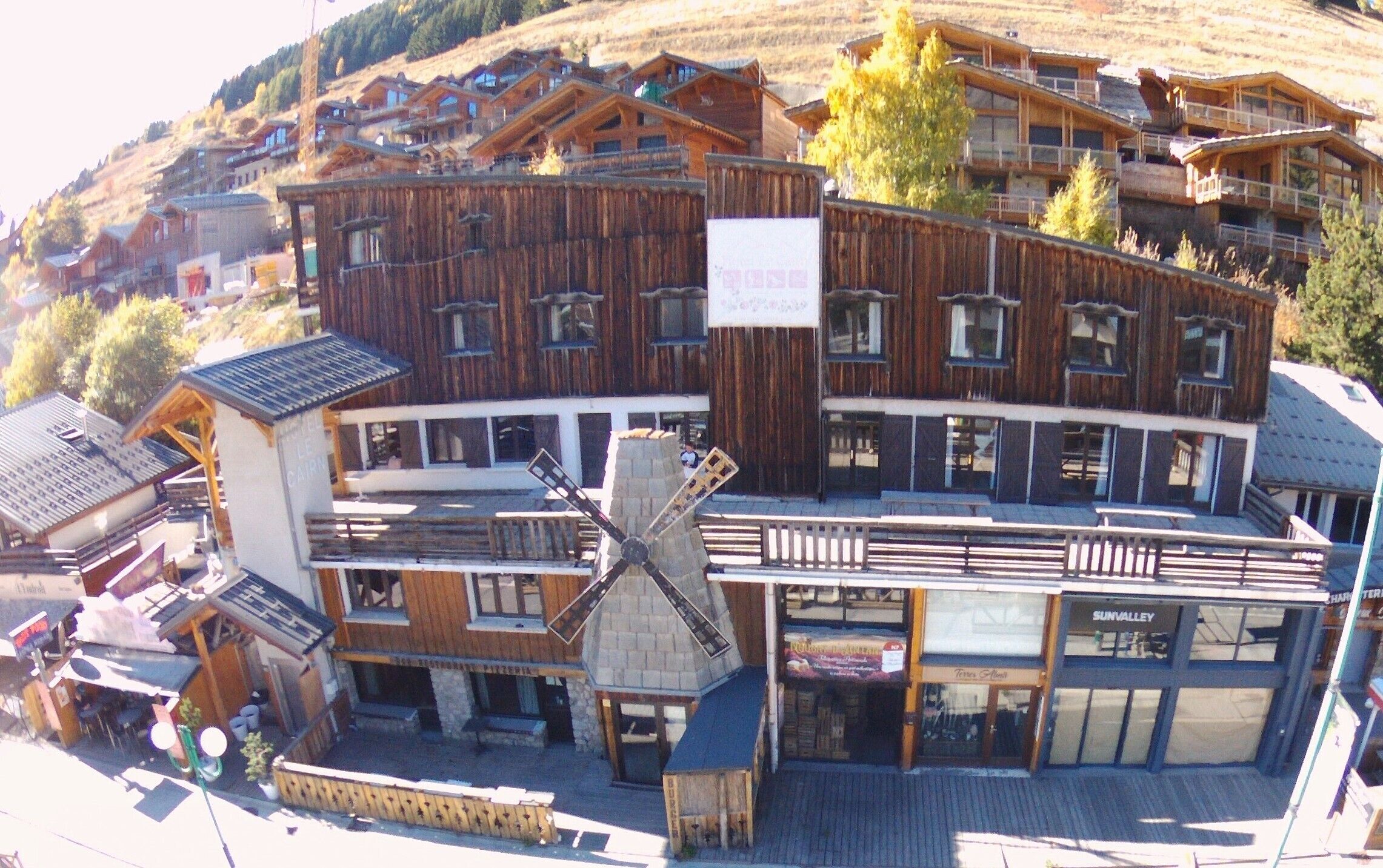 Un edificio de madera de varios pisos, con un restaurante y una tienda en la planta baja.