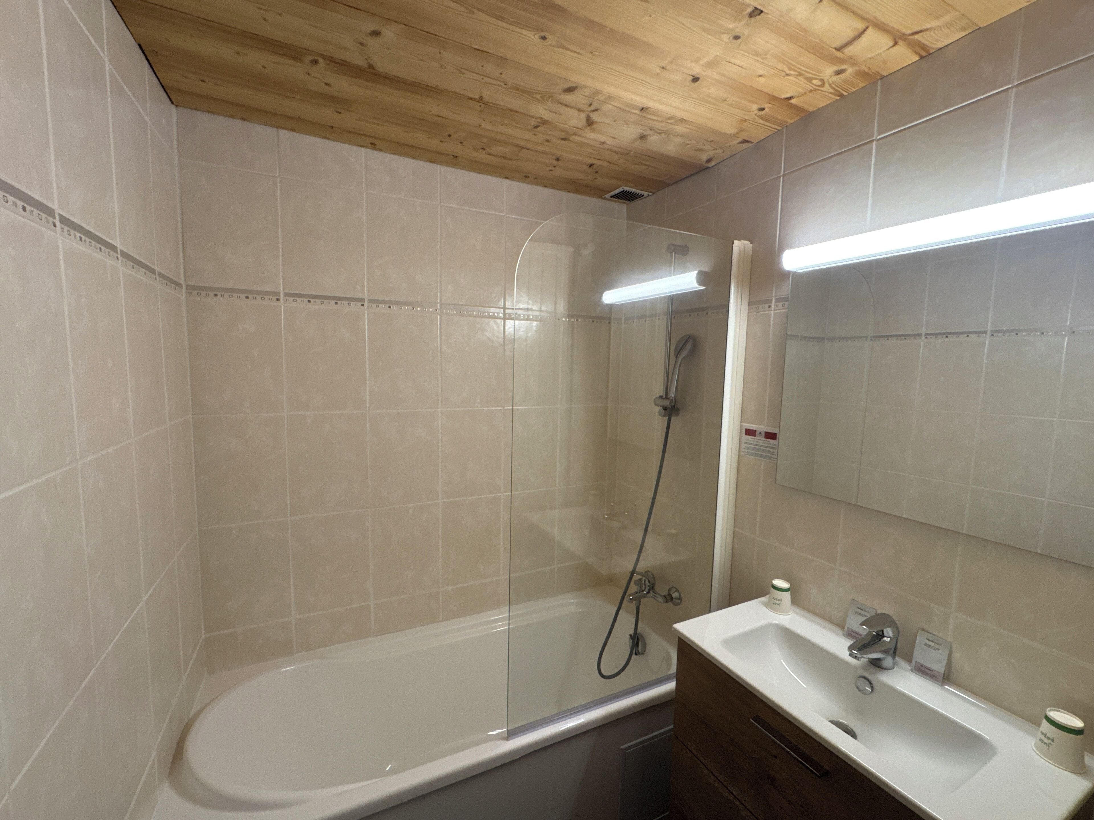 A bathroom with a bathtub, a shower, and a sink.