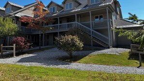 A multi-story residential building with a covered porch and a staircase leading to the upper levels.