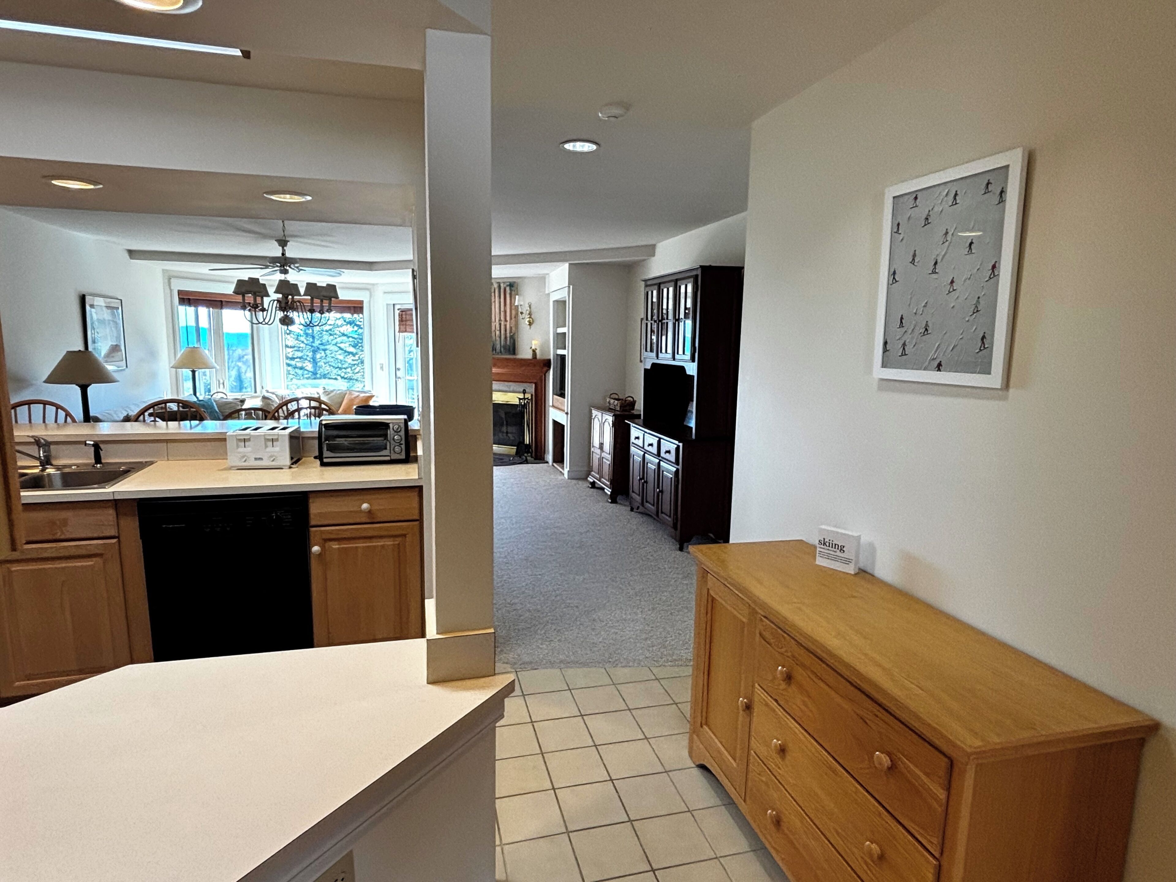 A modern kitchen with wooden cabinets, a built-in dishwasher, and a toaster.