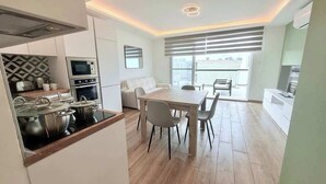 A modern kitchen with a dining area, a built-in oven, and a large window. - The Bugibba Central Penthouse! (Saint Paul's Bay)