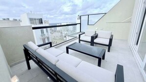 A rooftop terrace with a sofa set, a coffee table, and a dining table. - The Bugibba Central Penthouse! (Saint Paul's Bay)