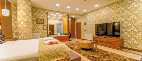 A hotel room with a bed, a TV, a wooden cabinet, and a mirror.