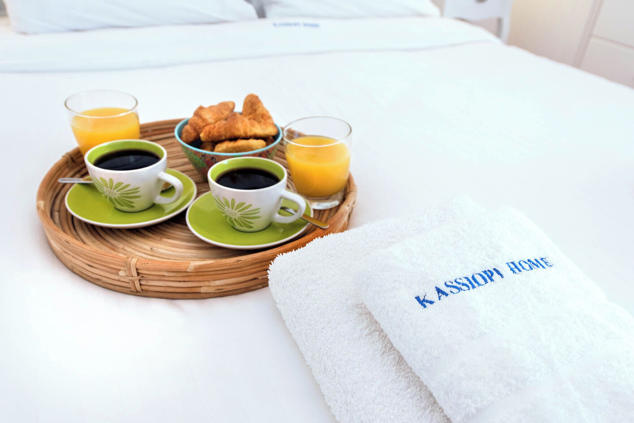 Ontbijtje op een bed met croissants, koffie en sinaasappelsap.