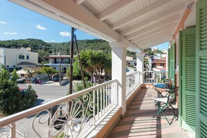 Un balcone con ringhiera, un tavolo e sedie.