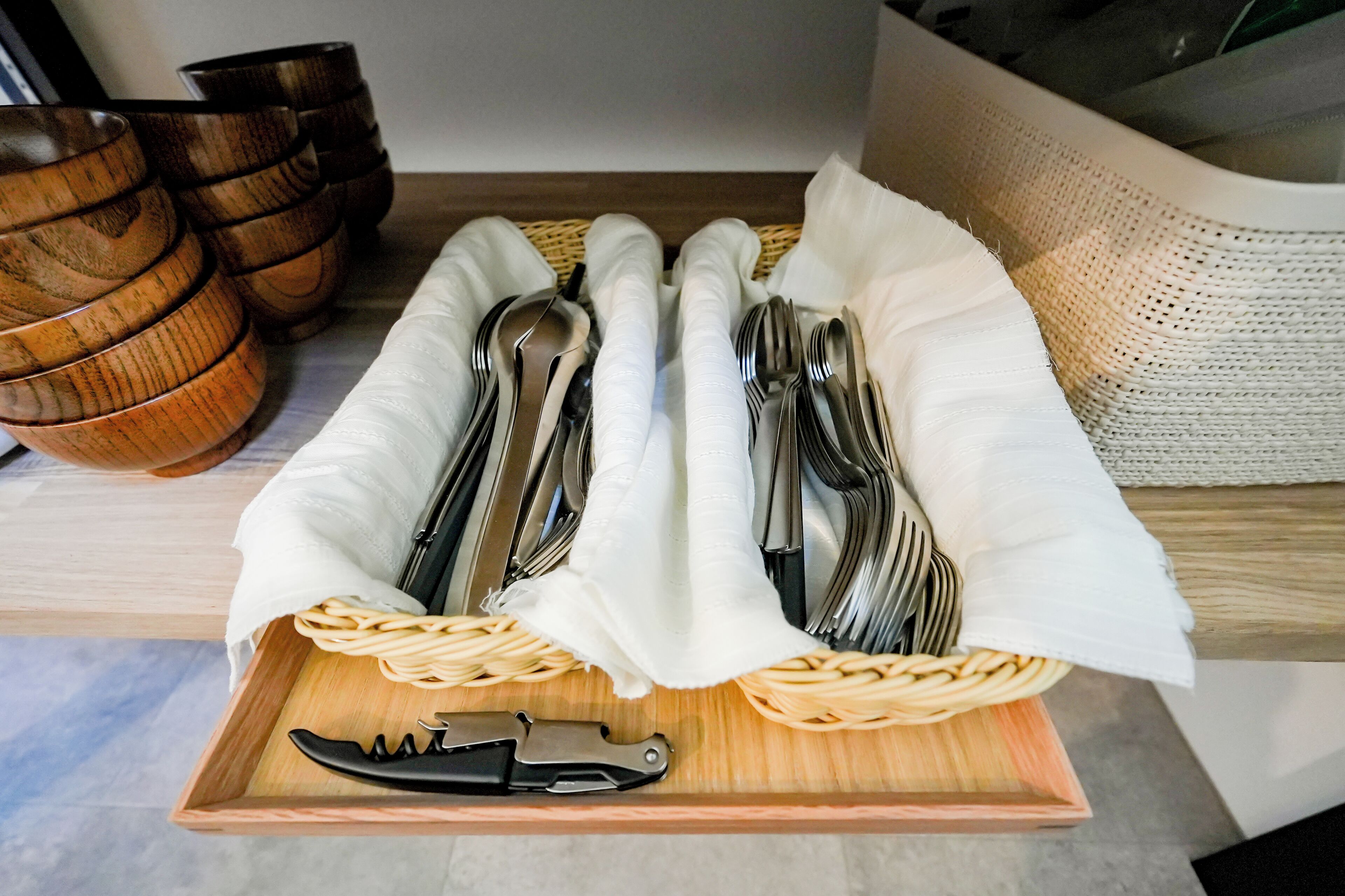 A tray with neatly arranged cutlery and a knife on a wooden surface.