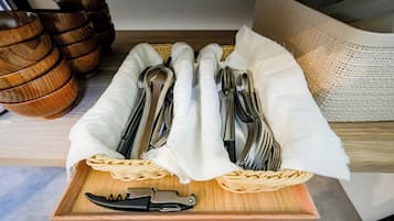 A tray with neatly arranged cutlery and a knife on a wooden surface.