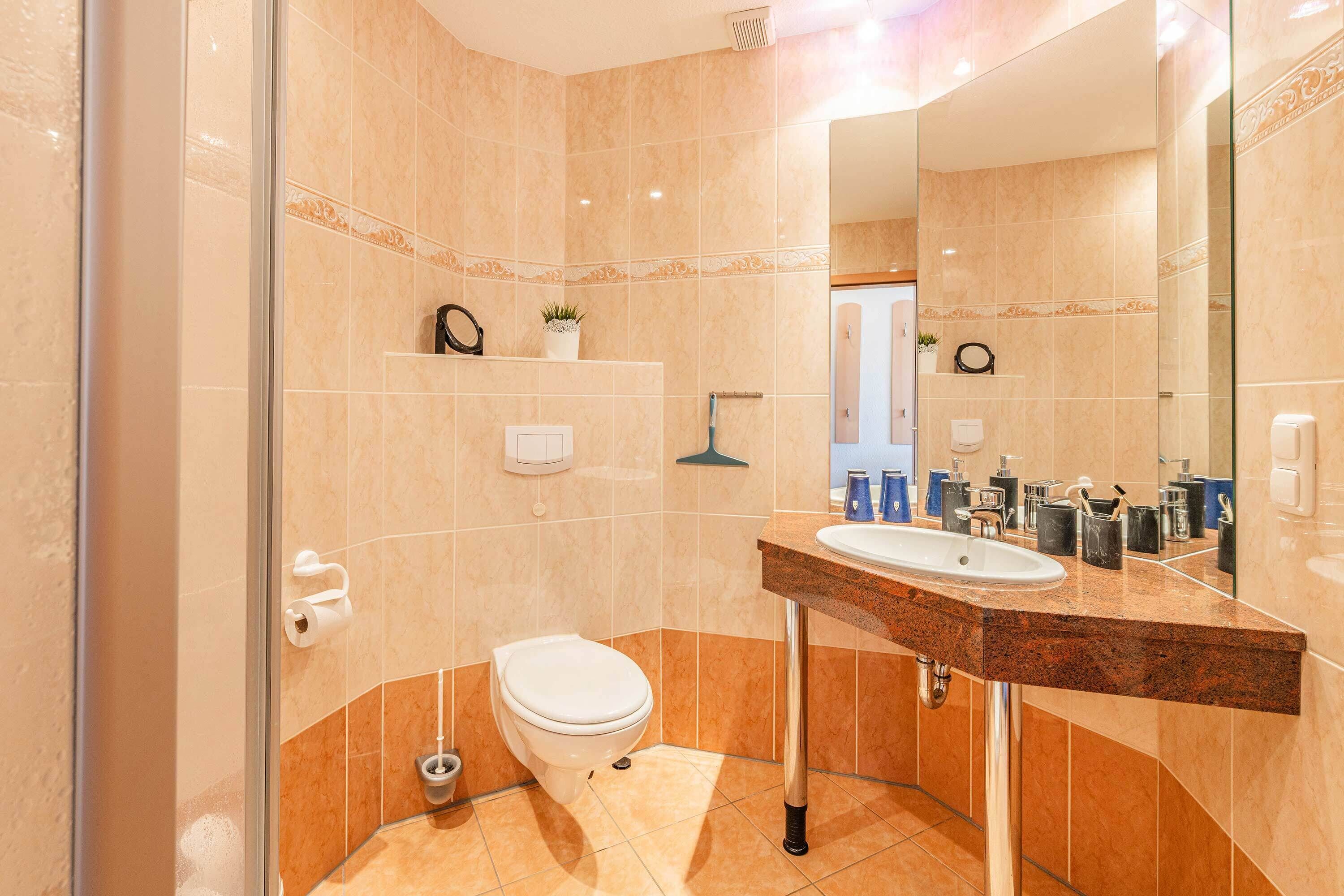 A bathroom with a toilet, sink, and shower.