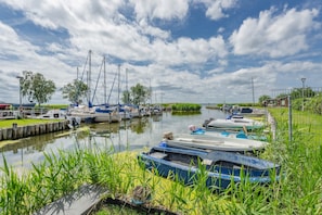 Un canal bordé de bateaux à quai, entouré de verdure et sous un ciel dégagé.