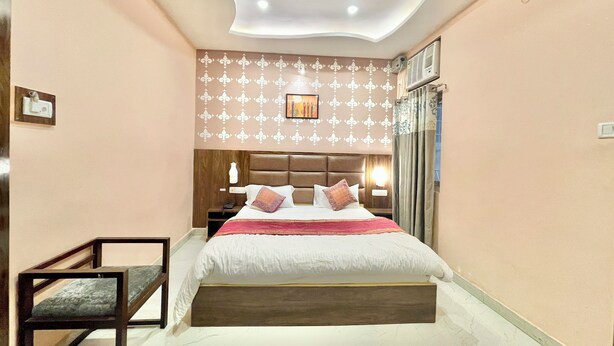 A bedroom with a bed, nightstands, a wall-mounted air conditioner, and a ceiling fan.
