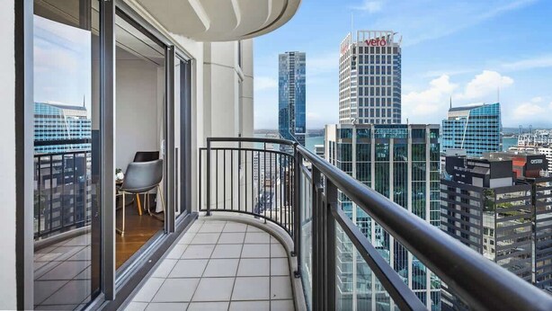Ein Balkon mit Blick auf hohe Gebäude, darunter ein Hotel 'Vero'.