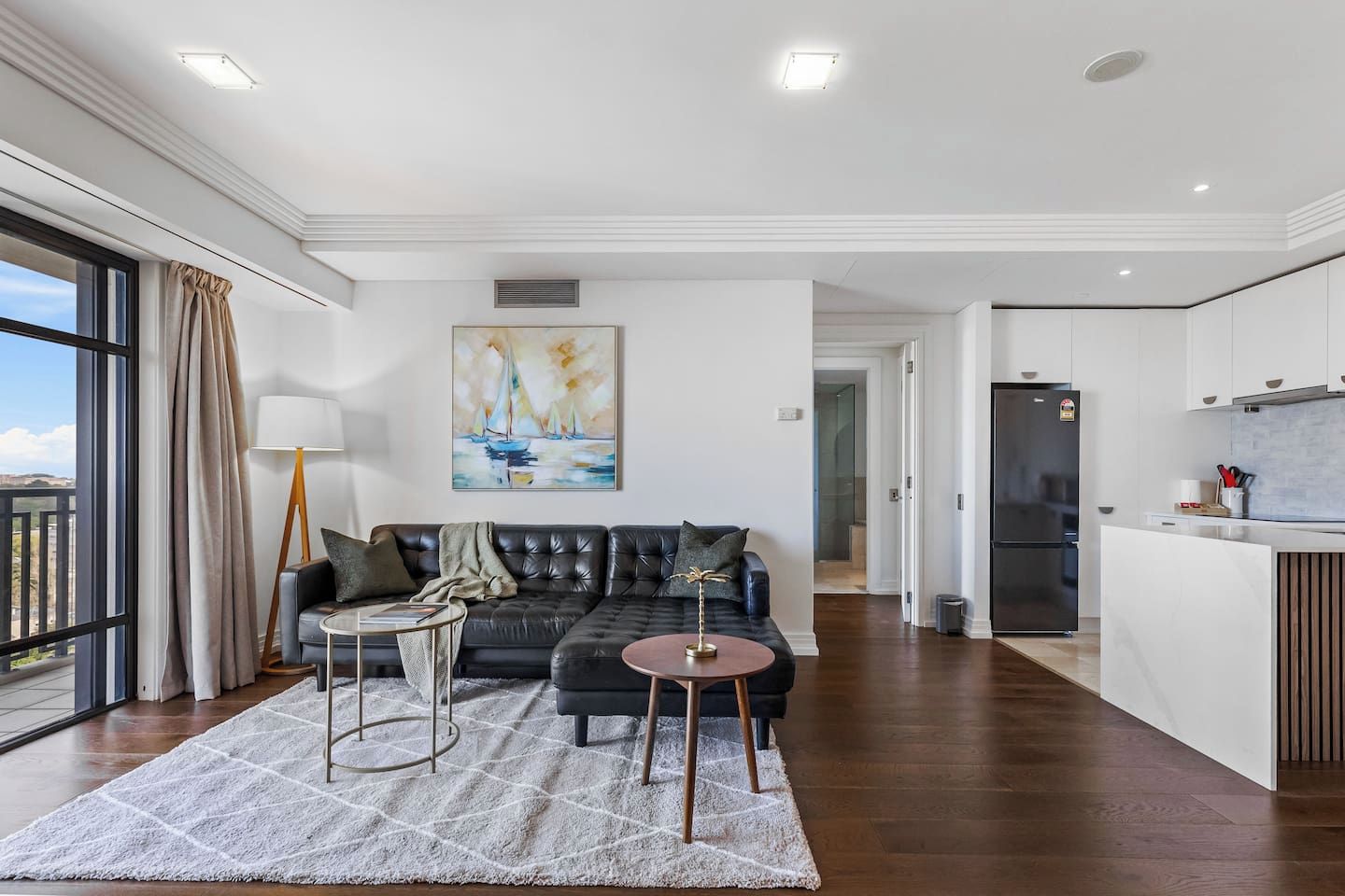 A modern living room with a sofa, a coffee table, and a painting on the wall.