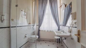 Une salle de bain avec une douche à parois de verre, des toilettes, un lavabo et un meuble-lavabo.