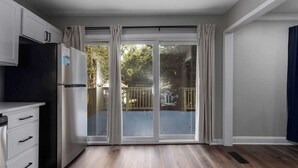 Une cuisine avec une porte-fenêtre coulissante donnant sur un jardin.