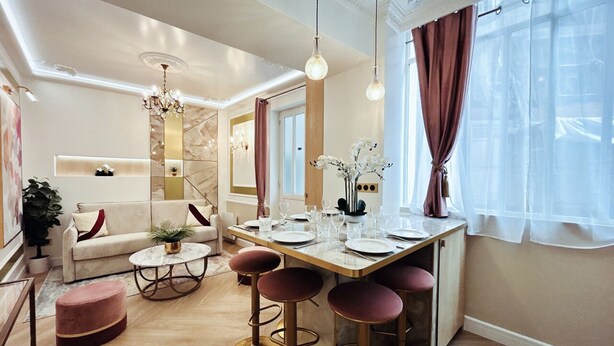 A modern living room with a dining area, featuring a sofa, coffee table, and bar stools. - Merveil Luxury Suite - Marais - Charlot (Paris)