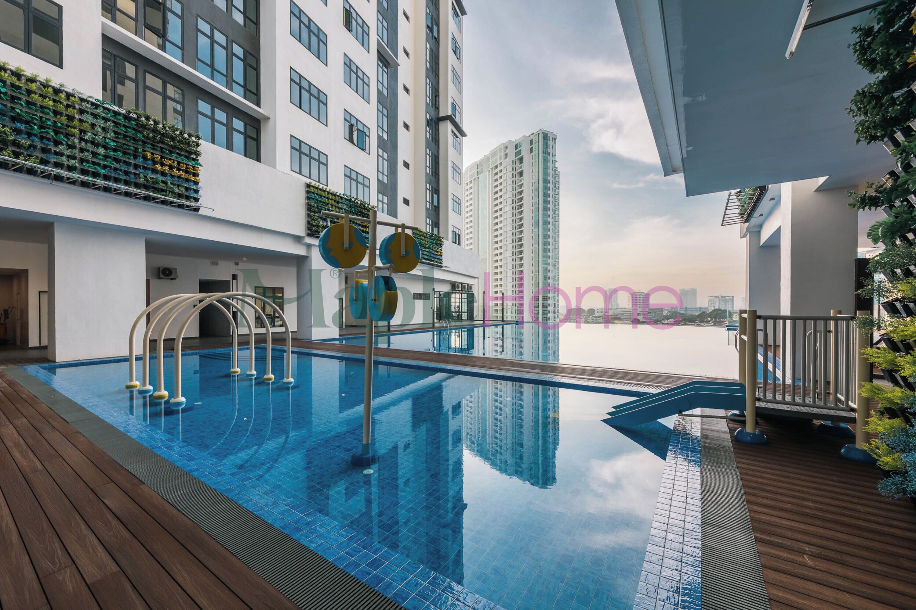 A rooftop pool with clear blue water, surrounded by wooden decking and metal railings.