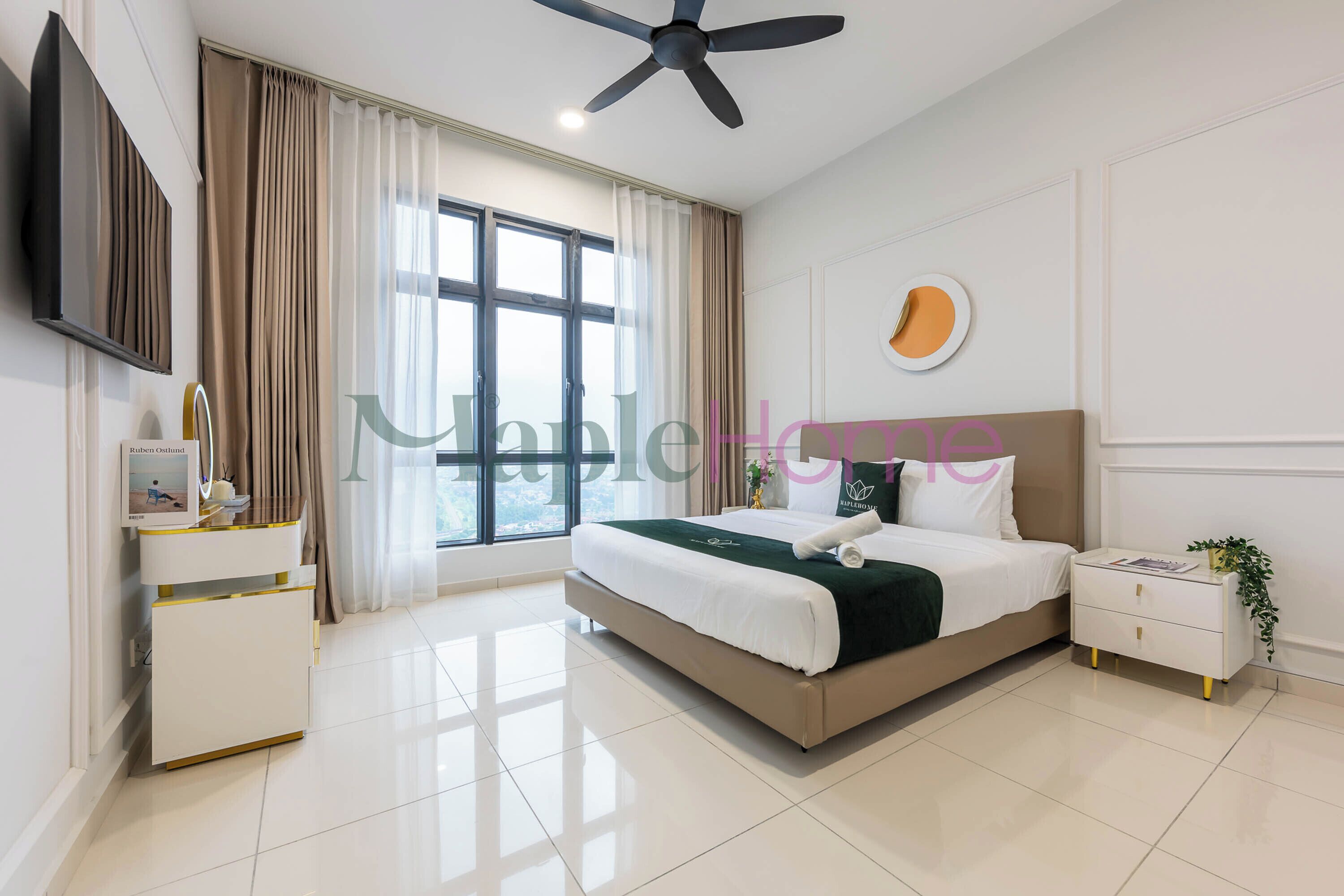 Una habitación de hotel moderna con una cama grande, una mesita de noche, un ventilador de techo, un televisor y una ventana con cortinas.