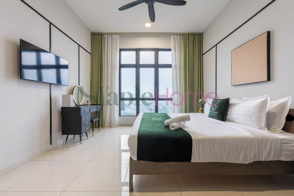 Een moderne hotelkamer met een groot bed, een flatscreen televisie, een bureau met spiegel en een raam met gordijnen.