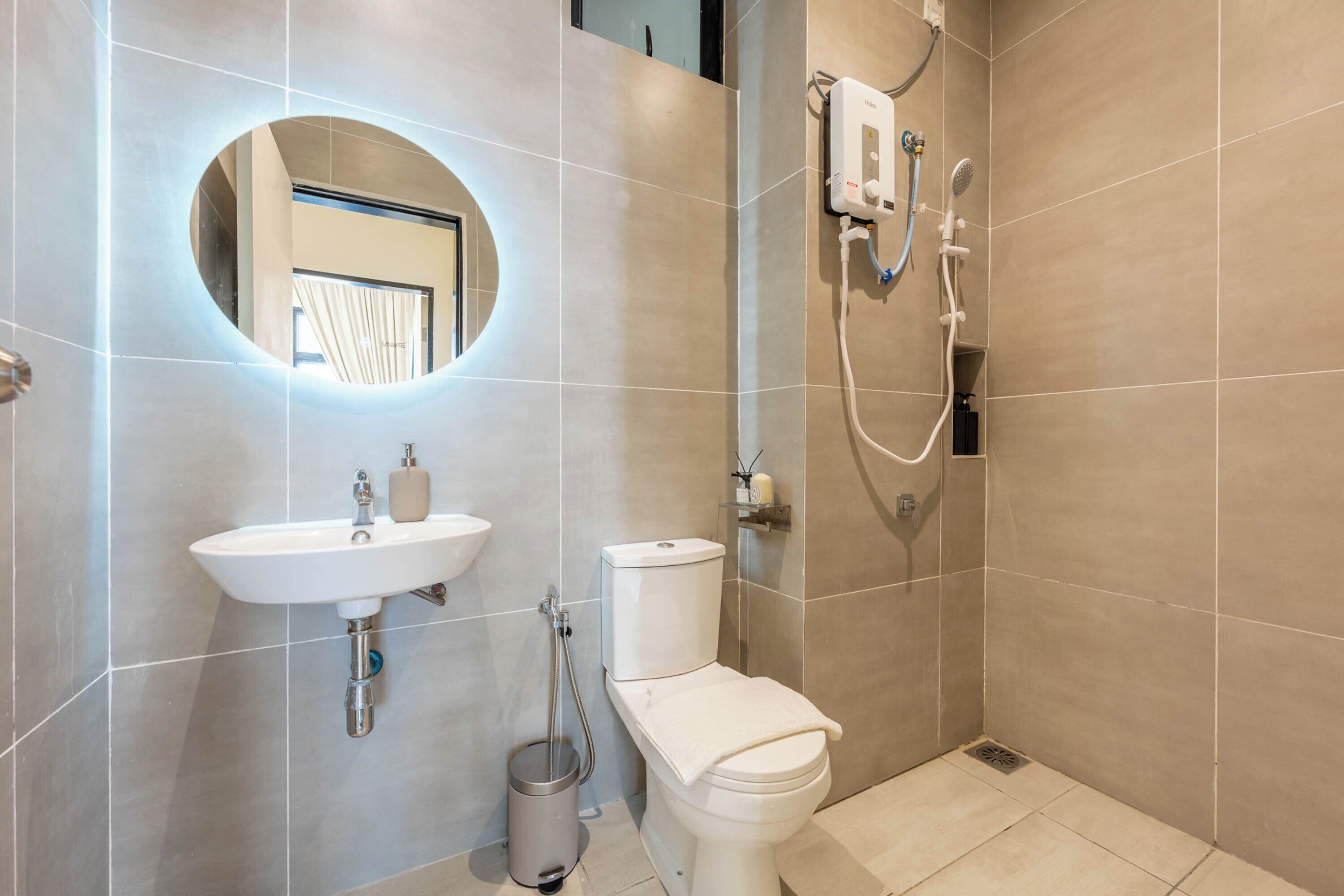 A modern bathroom with a sink, toilet, and shower.