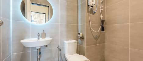 A modern bathroom with a sink, toilet, and shower.