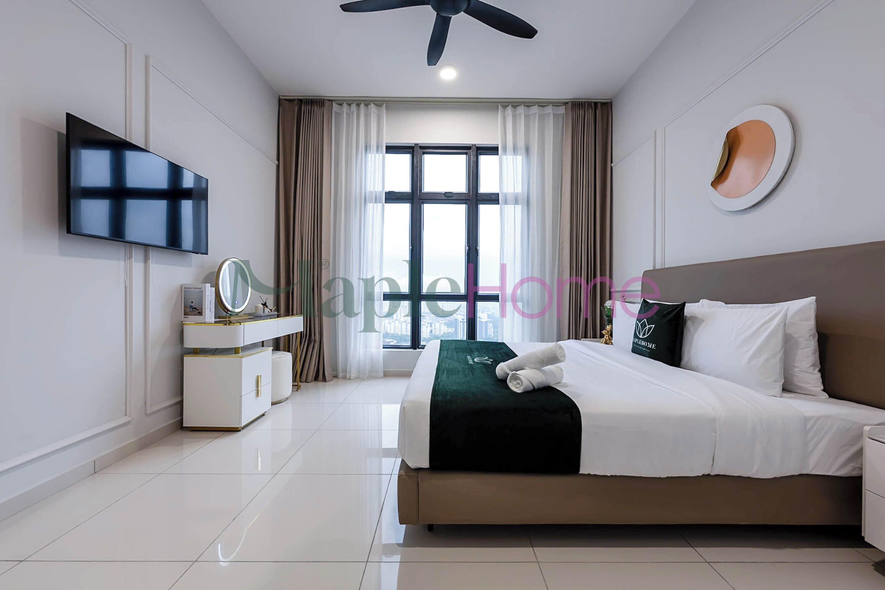A modern hotel room with a bed, a vanity with a mirror, a flat-screen TV, and a ceiling fan.