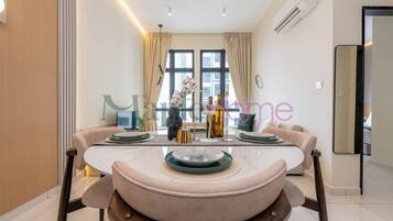 A modern dining area with a round table, cushioned chairs, and a vase of flowers.