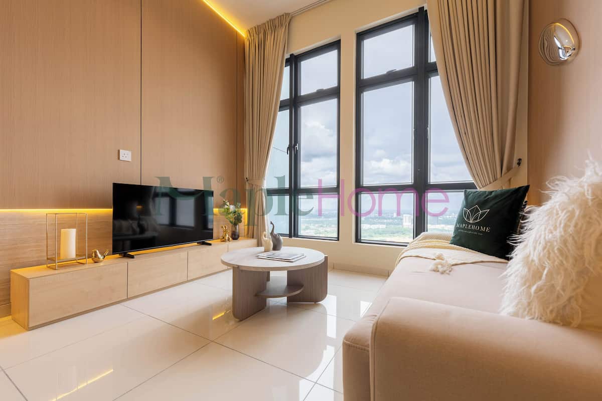 Een moderne woonkamer met een flatscreen televisie, een ronde salontafel en een bank met een zacht kussen.