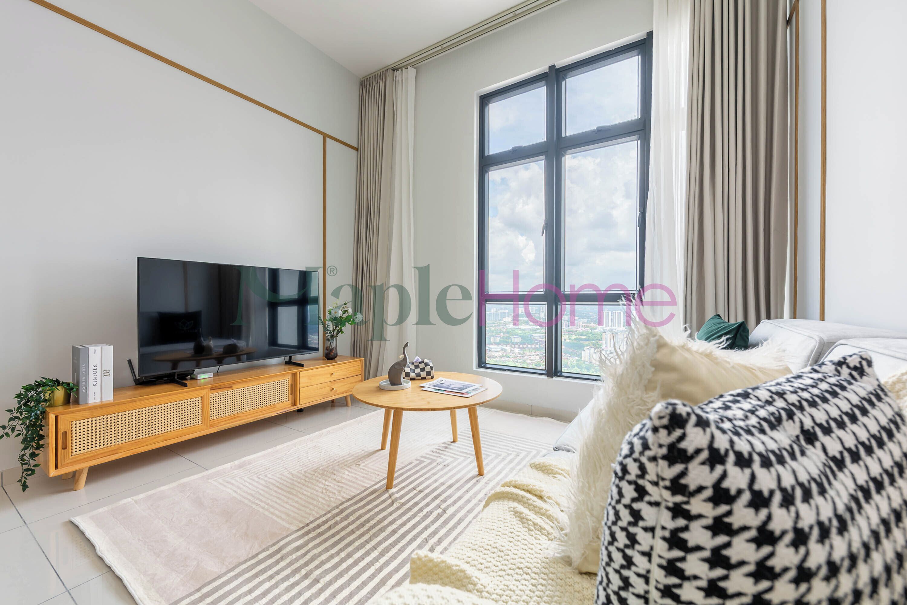A modern living room with a large window, a flat-screen TV, a wooden console table, and a cozy sofa.