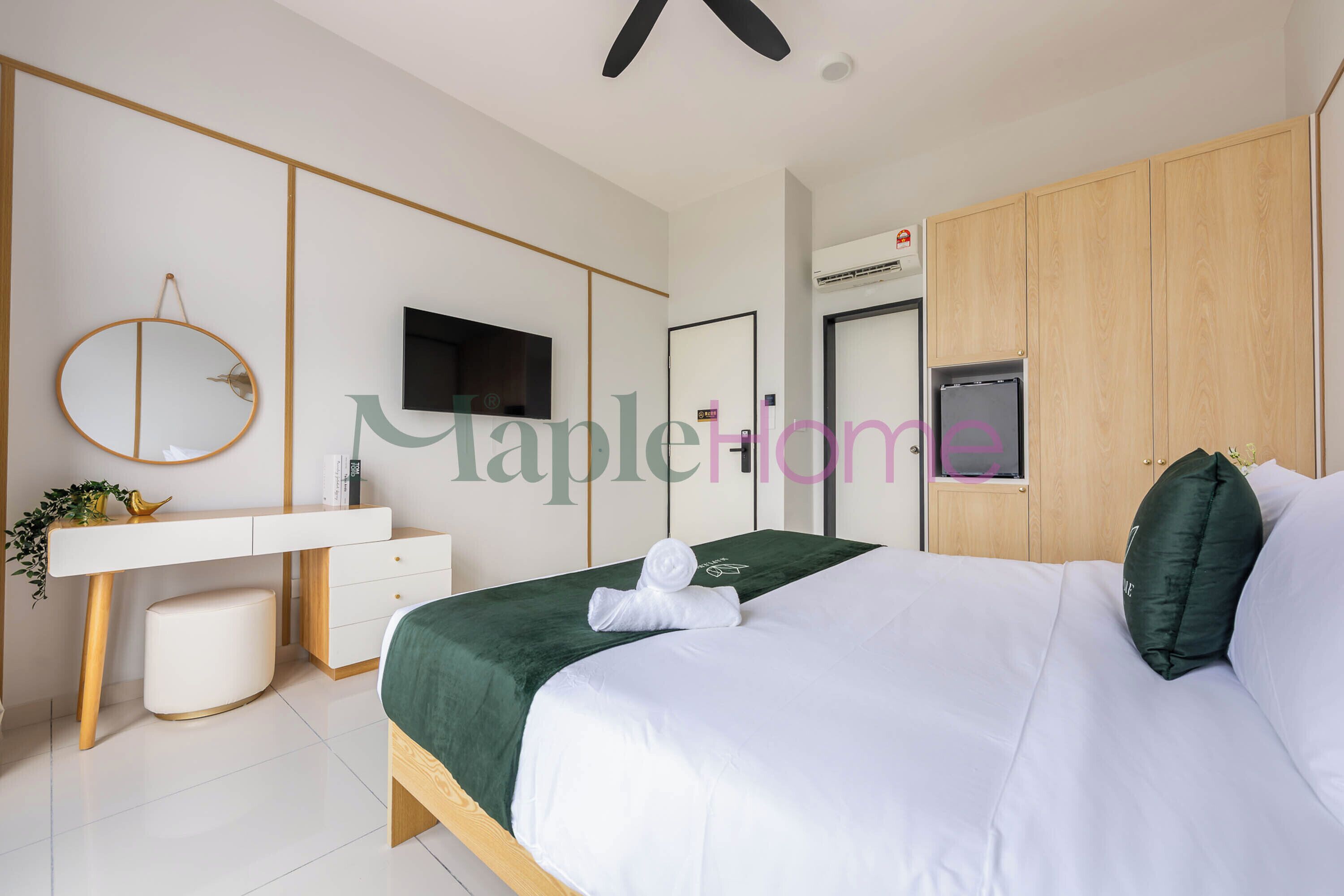 Um quarto moderno com uma cama, escrivaninha, espelho, televisão e guarda-roupa.