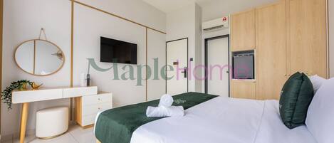 Um quarto moderno com uma cama, escrivaninha, espelho, televisão e guarda-roupa.