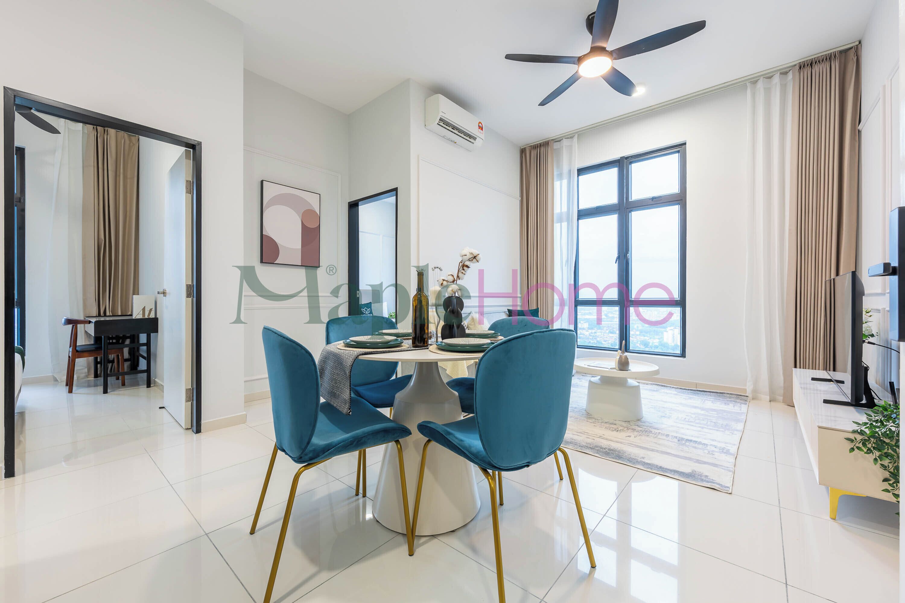 A modern dining area with a round table, blue chairs, and a ceiling fan.