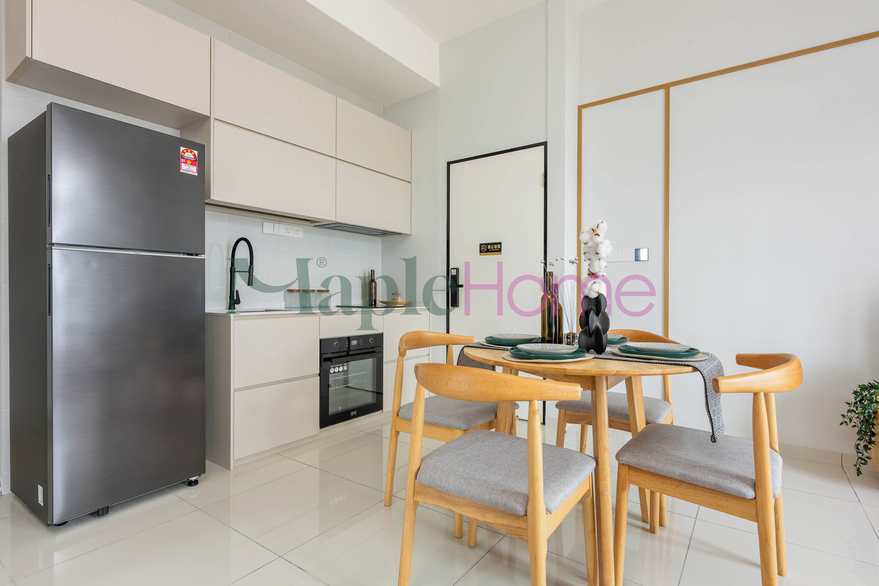 Una cocina moderna con un refrigerador de acero inoxidable, horno empotrado y una zona de comedor con sillas y mesa de madera.