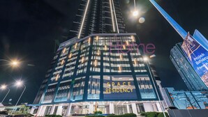 Un bâtiment moderne, doté d'une enseigne bien visible indiquant « SPACE RESIDENCY », de grandes fenêtres et d’une façade bien éclairée.