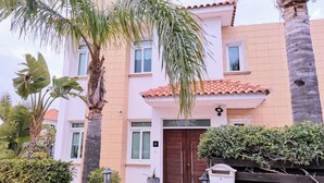 A two-story building with a tiled roof, a brown door, and a mailbox. - Artemis Villa in Protaras 100m From the Sea (Paralimni)