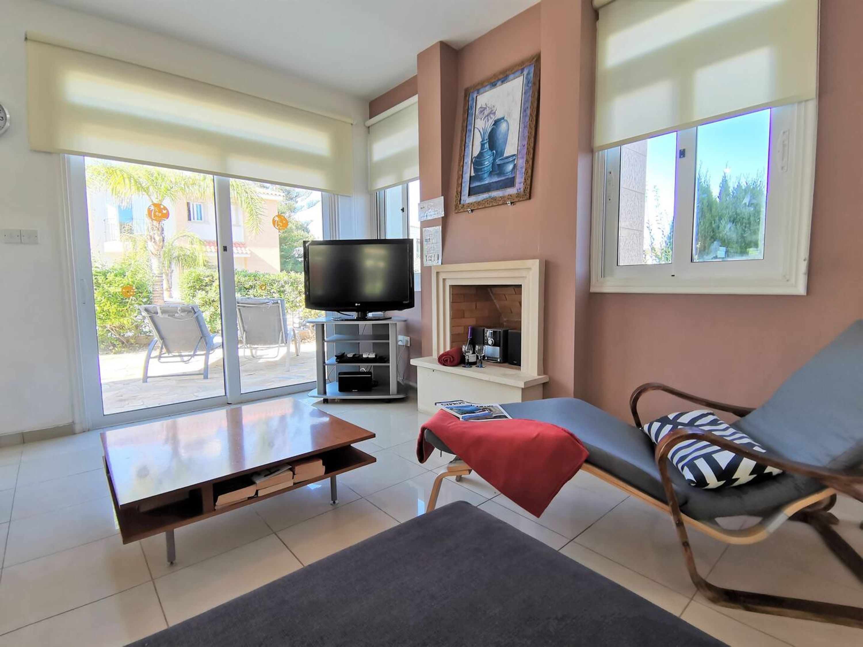 A living room with a TV, a fireplace, a sofa, and a dining table.