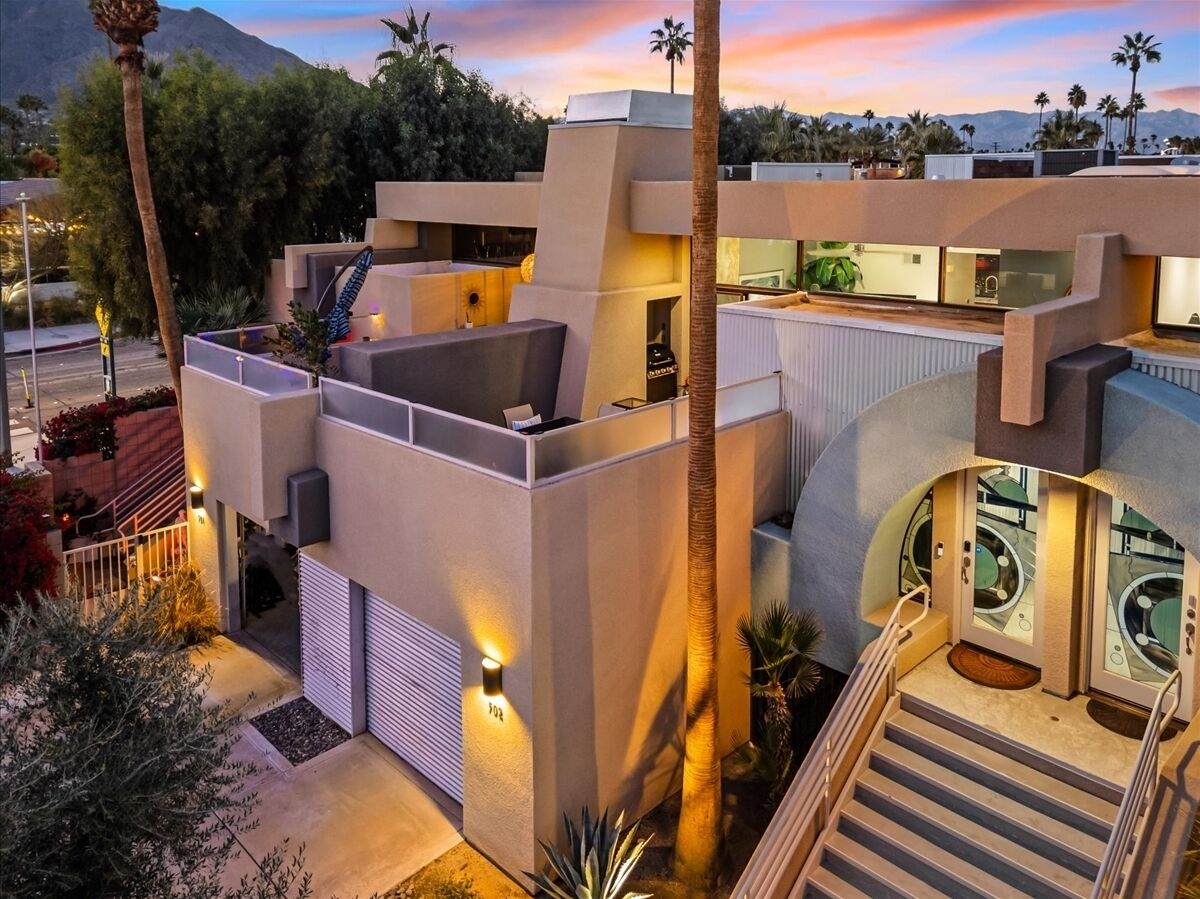 A modern building with a rooftop terrace, a staircase, and a pool area.