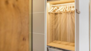 Un vestidor con estantes de madera y espacio para colgar.